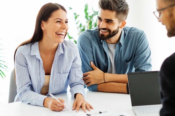 Real estate agent with couple shaking hands closing a deal