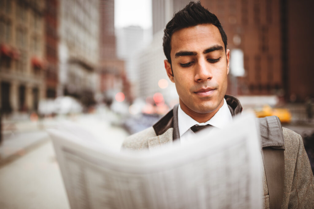 business man reading a newspaper on manhattan