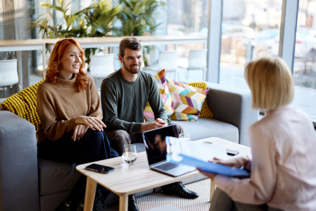 Happy talking about future plans with their financial professional in an office.