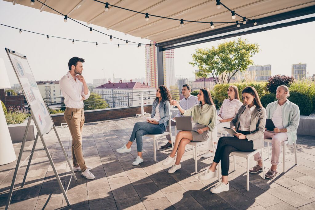 young man leading a meeting with clients outdoors