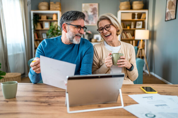 Cheerful mature couple managing retirement planning together
