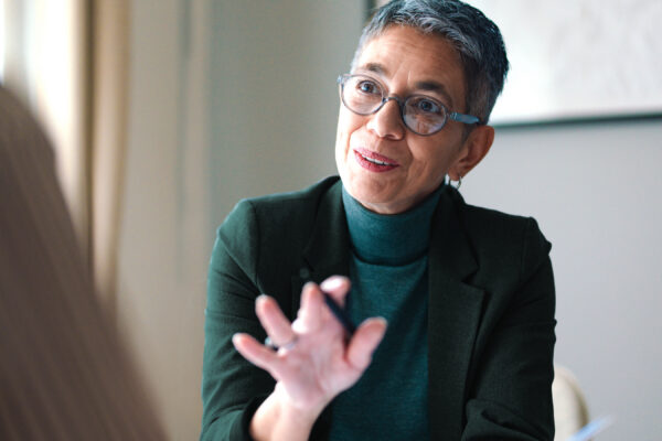 confident woman advising client across table with pen and paper in hand