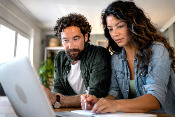 Middle aged couple researching retirement strategies on a laptop